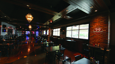 4-top tables at 99 Hops House with brick wall and chandelier