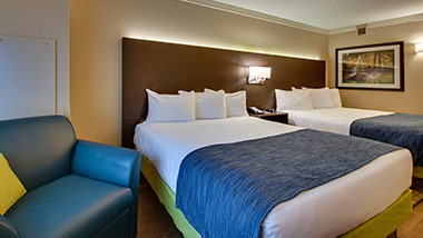 hotel room with two queen beds and sitting chair