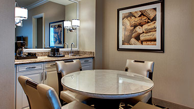 Hotel suite with dining table and wet bar