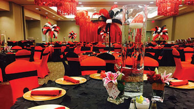 Red chandeliers hang over black tables surrounded by red and black decorated chairs inside the banquet space at Hollywood Casino in St. Louis, Missouri.