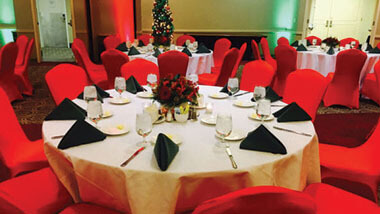 Chairs covered in red material surround a circular table set with a white table cloth and black napkins inside Hollywood Casino in St. Louis, Missouri.