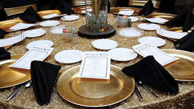 Menus lie on gold plates on a gold table cloth with black napkins inside the banquet space at Hollywood Casino in St. Louis, Missouri.