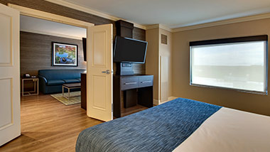 hotel suite with king bed, tv, living room