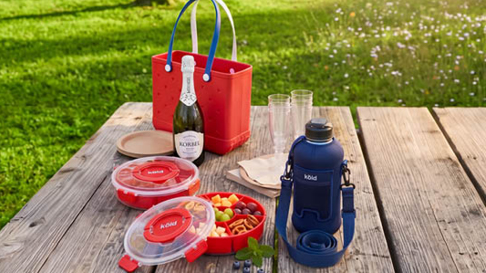 beach bag, snackle box and water bottle on table