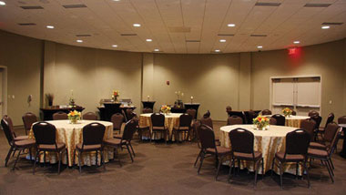 Circular tables set with white table cloths and surrounded by black chairs inside the banquet space at Hollywood Casino in St. Louis, Missouri.
