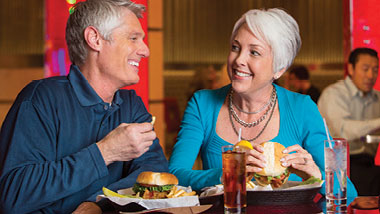 An older couple smiles as they eat burgers at Hollywood Casino in St. Louis, Missouri.