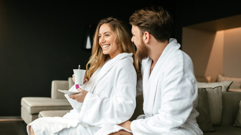 couple eating breakfast in hotel bed